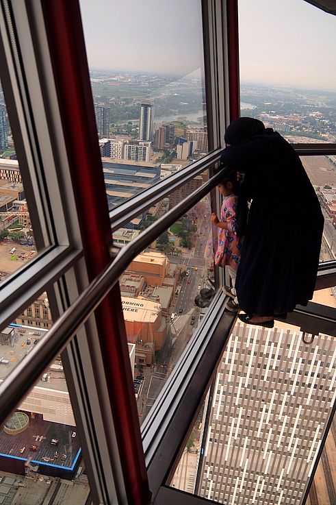 Vue de la ville depuis le sol vitré de la Calgary Tower.