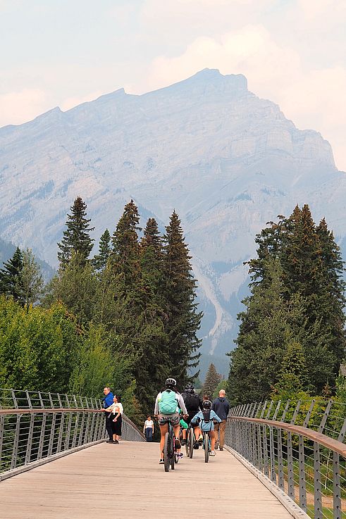 Passerelle piétonne sur la rivière Bow avec vue sur le mont Rundle à Banff.