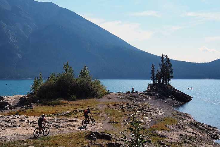 Cyclistes en VTT sur les rives du lac Minnewanka.