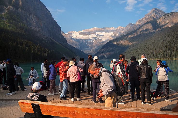 Touristes au bord du lac Louise face au glacier Victoria, dans le parc national de Banff.