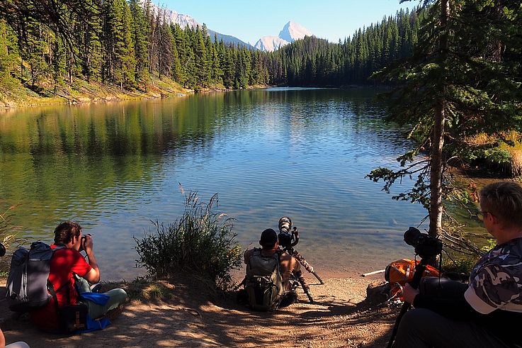 Photographes au bord d'un lac alpin dans le parc national Jasper.
