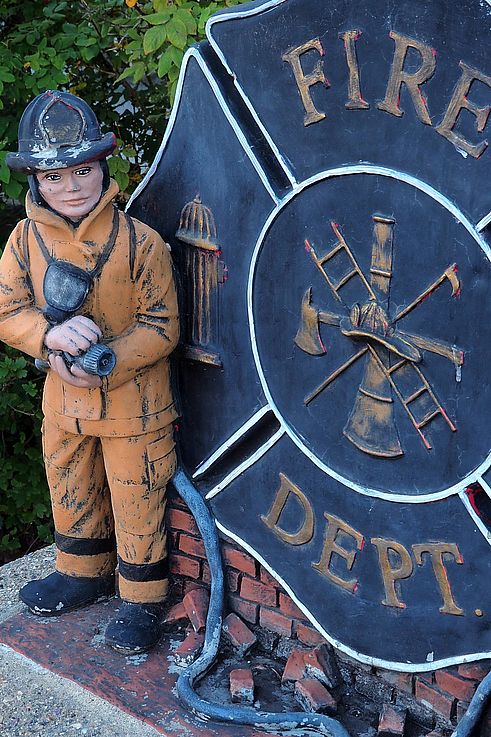 Statue de pompier devant l'emblème du service d'incendie de Jasper.