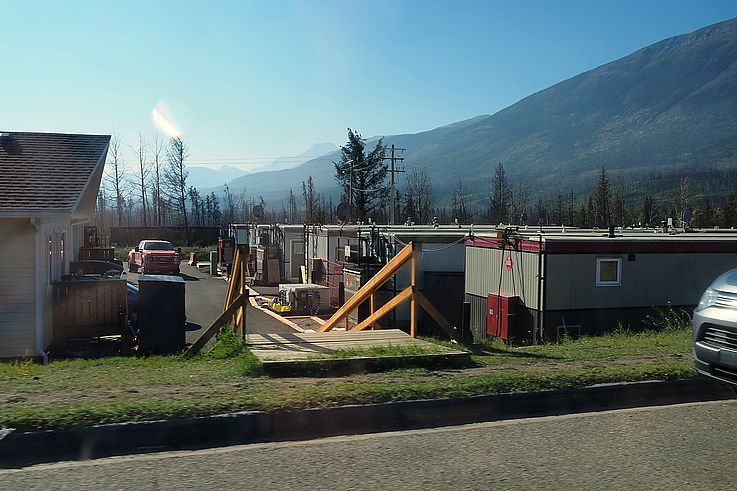 Bungalows et logements temporaires au pied des montagnes à Jasper, après le passage d'un incendie de forêt.