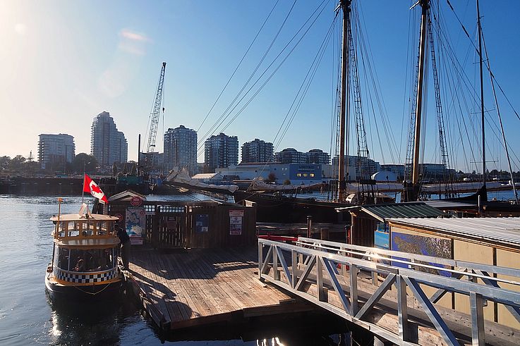 Water taxi at Mermaid Wharf with the sailboat Pacific Grace in Victoria.