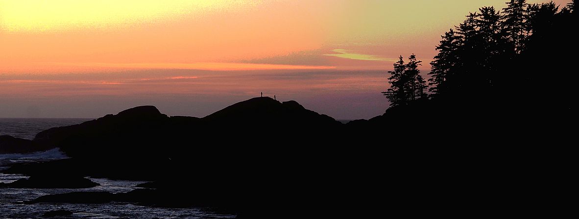 Silueta de caminantes en el Wild Pacific Trail en Ucluelet al atardecer.