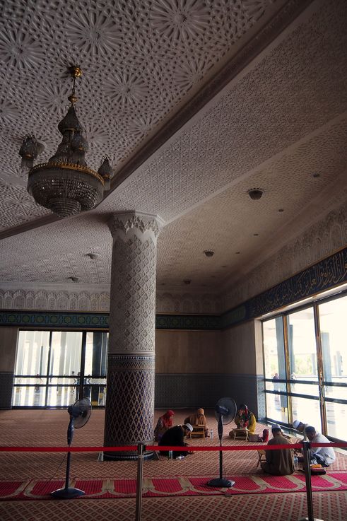 Interior of Masjid Negara in Kuala Lumpur with worshippers praying.
