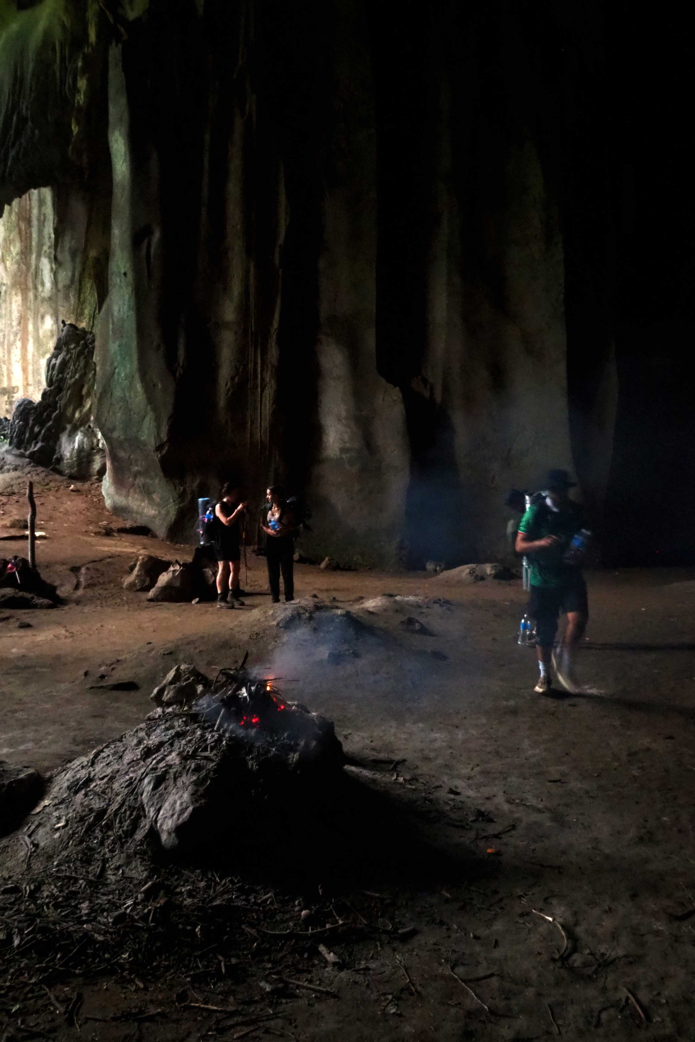 Personas cerca de una fogata en una cueva en el sendero de Kumbang, Parque Nacional Taman Negara.