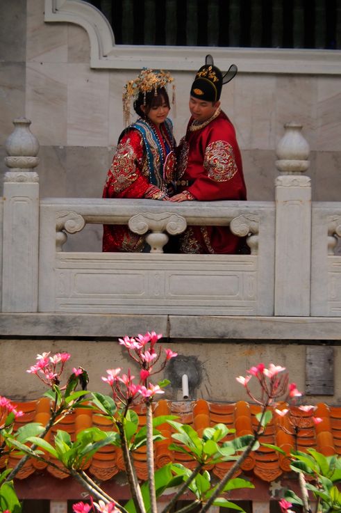 Newlyweds in traditional attire at Kek Lok Si Temple in George Town.