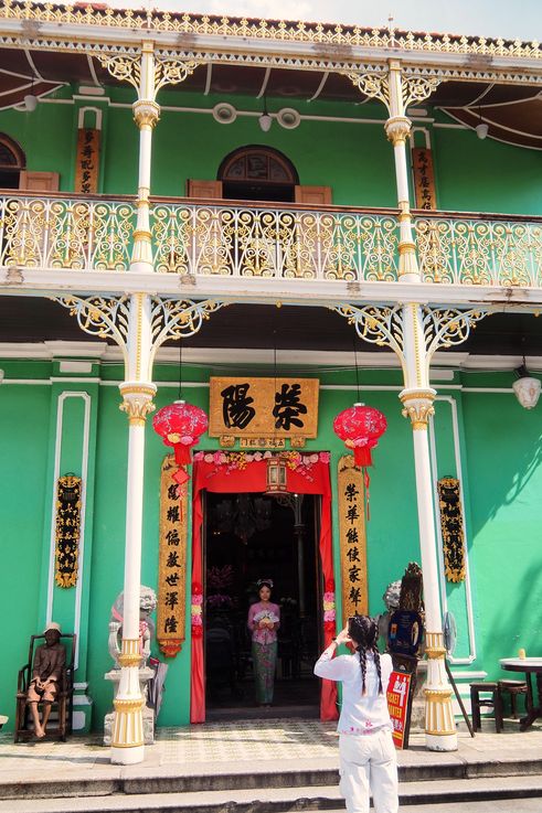 Facade of the Pinang Peranakan Mansion in George Town and statues.