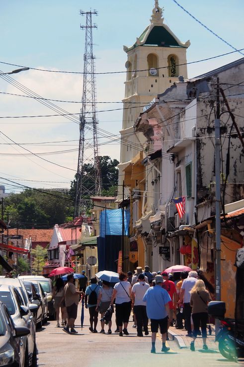Escena callejera frente a la Iglesia de San Pedro en Melaka.