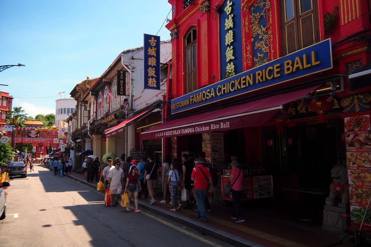 León de piedra y restaurante Famosa Chicken Rice Ball en la calle Jonker Walk en Melaka.