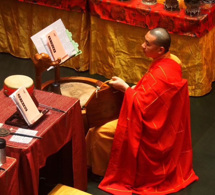 Monje y tambor de madera en el Templo de la Reliquia del Diente de Buda en Chinatown.