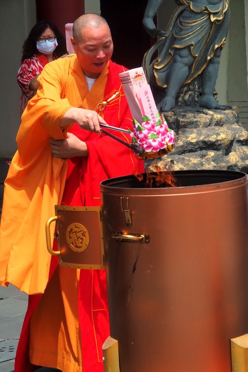 Monje budista ofreciendo una flor en el Templo de la Reliquia del Diente de Buda.