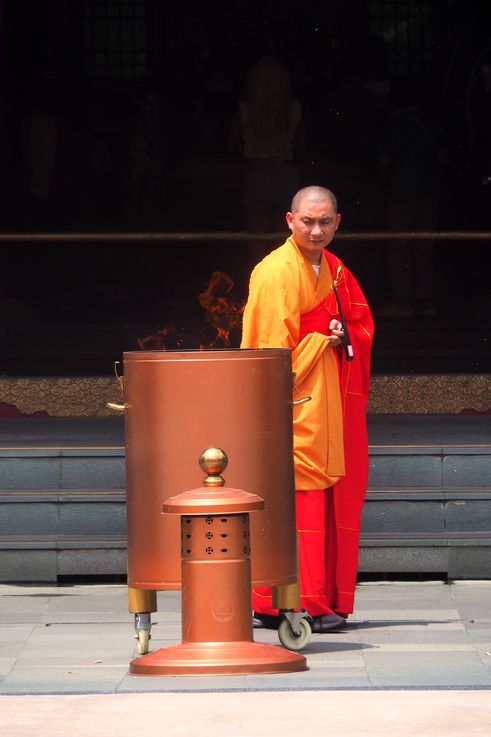 Monje y incensario en el Templo de la Reliquia del Diente de Buda.