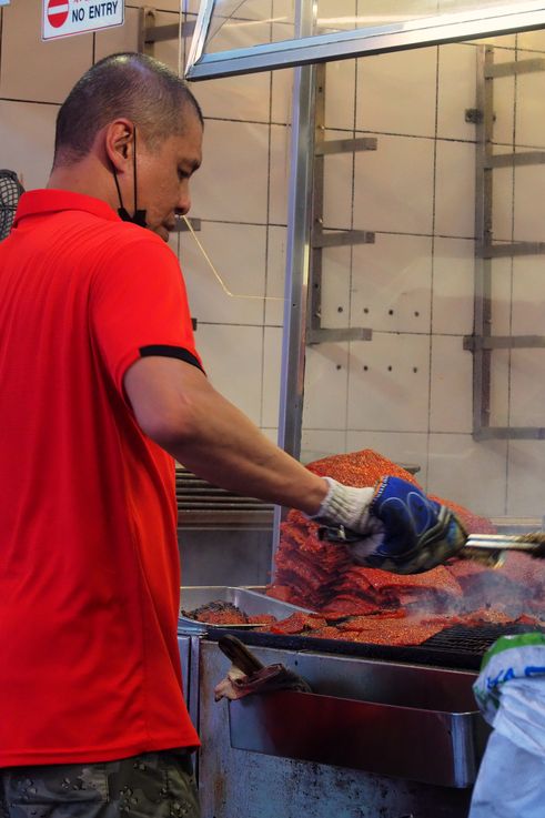 Preparación de bak kwa a la parrilla por un hombre en Kim Hwa Guan Bak Kwa, Chinatown.